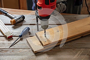 Drill electric tool, hand drilling wood. Construction industry, carpenter work bench table