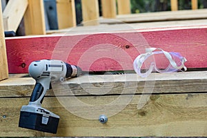 drill and protective glasses on the background of construction