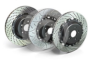 Drilled and slotted brake disks in a row. Different types of brake disks photo