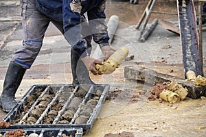 Driller obtaining soil samples in plastic core box