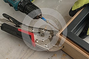 Drilling a hole in the door frame for a corner connection.