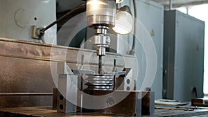 Drilling a hole with a drilling machine in a metal workpiece pulley, close-up, industry, reaming