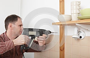 Drilling the hole in a kitchen wall