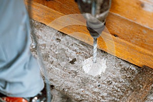 Drilling holes in a concrete block with a hammer drill power tool