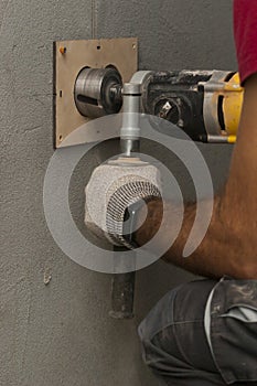 Drilling holes in the wall for an electrical outlet box or switch