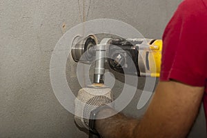 Drilling holes in the wall for an electrical outlet box or switch
