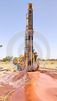 Drilling machine digging hole in the ground for water