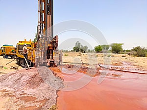 Drilling machine digging hole in the ground for water photo