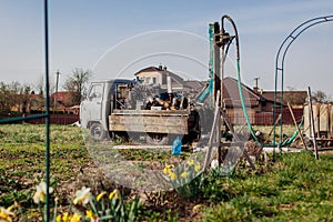 Drilling machine digging water in ground for well installation. Geology rig work equipment