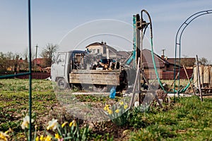 Drilling machine digging water in ground for well installation. Geology rig work equipment photo