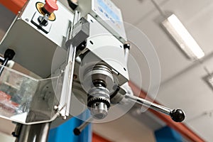 Drilling machine. New Industrial Iron drill in workshop interior. Tool store or exposition stand.