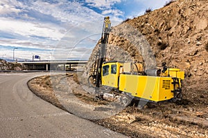 Drilling machine in the works of expansion of a roadDrilling rock in the works of creating a road