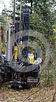 Drilling rig drills soil in forest conditions