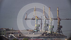 Drilling rigs at oil field on ocean coast near lighthouse