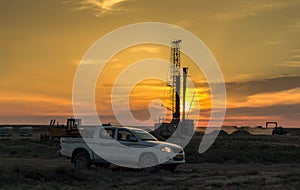 Drilling rigs at sunset.