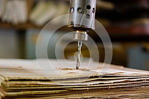 drilling through thick paper stack with bookbinding drill