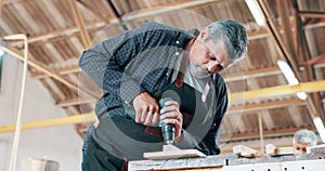 Drilling, wood and carpenter in workshop with tools for construction of project on table in warehouse. Handyman