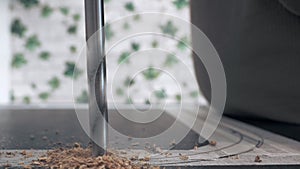 Drilling wood with a drill. Close-up of furniture assembly.