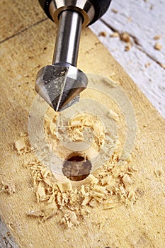 Drilling in wood with steel drills and countersinks. Minor carpentry work in the workshop