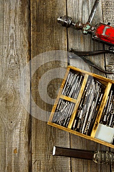 Drills in box, drill, chisel on a wooden