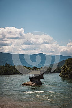 Drina river house on a rock with clouds behind