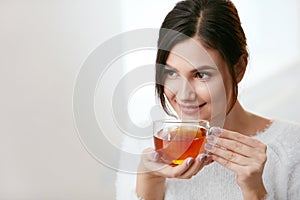 Drink. Beautiful Woman Drinking Tea From Cup photo