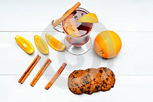 Drink or beverage with orange and cinnamon, top view. Cocktail and bar concept. Mulled wine near slices of orange.Glass