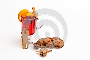 Drink or beverage with orange and cinnamon, top view. Glass with mulled wine with cookie and wooden silhouette of couple