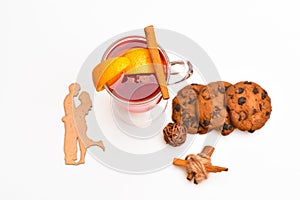 Drink or beverage with orange and cinnamon, top view. Glass with mulled wine with cookie and wooden silhouette of couple