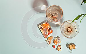 Drink champagne or wine in two elegant glasses and a bar of white chocolate gentle blue background. Concept minimalism.