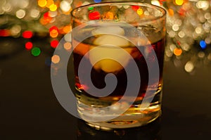 Drink Cuba Libre, rum with cola in an old fashoned glass with two ice balls photo