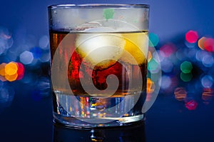 Drink Cuba Libre, rum with cola in an old fashoned glass with two ice balls photo