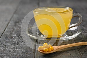 Drink ginger root, lemon, orange, honey and cinnamon and yellow pils on a dark wooden table