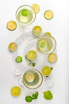 Drink glasses with water ,lime,mint and ice on white background