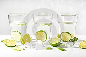 Drink glasses with water ,lime,mint and ice on white background