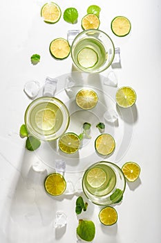 Drink glasses with water ,lime,mint and ice on white background