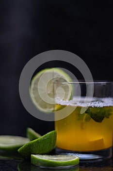 Drink, juice in a glass with a lemon slice, mint and cut lemons around