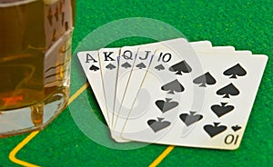 Drink on poker table with cards