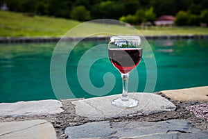 Drink in tall glass in poolside. Refreshment on summer day. Purple juice cocktail or vine.