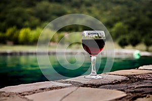 Drink in tall glass in poolside. Refreshment on summer day. Purple juice cocktail or vine.