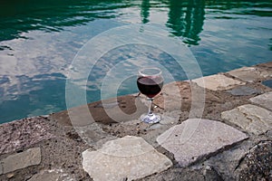 Drink in tall glass in poolside. Refreshment on summer day. Purple juice cocktail or vine.