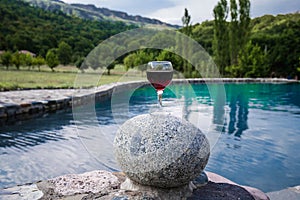 Drink in tall glass in poolside. Refreshment on summer day. Purple juice cocktail or vine.