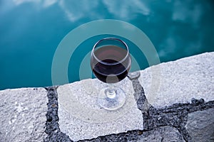 Drink in tall glass in poolside. Refreshment on summer day. Purple juice cocktail or vine.