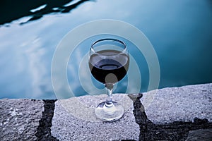 Drink in tall glass in poolside. Refreshment on summer day. Purple juice cocktail or vine.