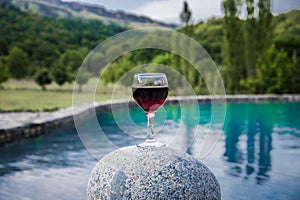 Drink in tall glass in poolside. Refreshment on summer day. Purple juice cocktail or vine.