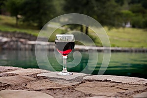 Drink in tall glass in poolside. Refreshment on summer day. Purple juice cocktail or vine.