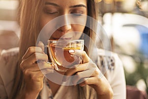 Drink Tea relax cosy photo with blurred background. Female hands holding mug of hot Tea in morning. Young woman relaxing tea cup