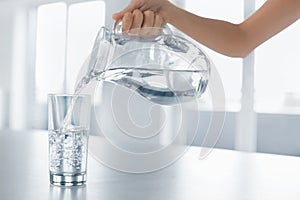 Drink Water. Woman's Hand Pouring Water From Pitcher Into A Glas