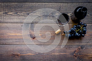 Drink wine concept. Bottle, glass, grape on wooden background top view copyspace