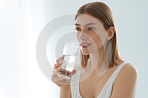 Drink. Woman drinking fresh pure water from glass portrait